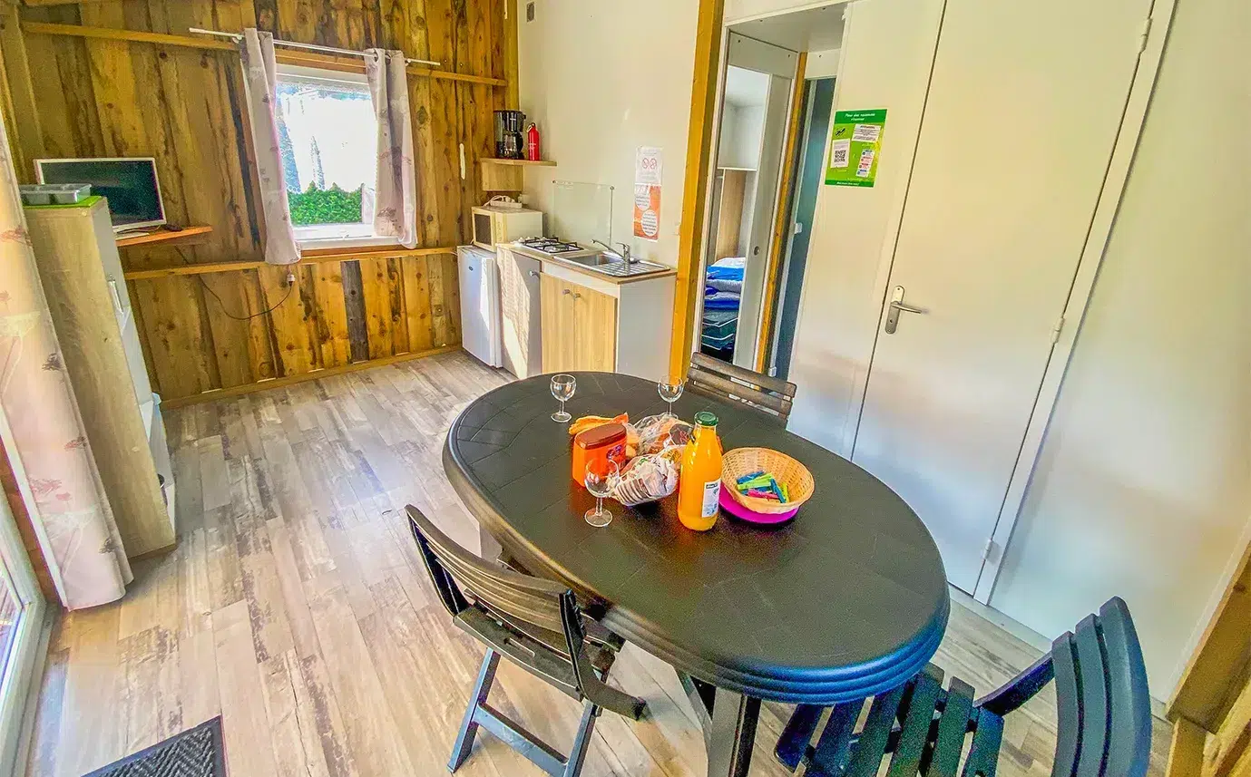 Coin repas et murs en bois du chalet Tithome, hébergement insolite près du Puy du Fou