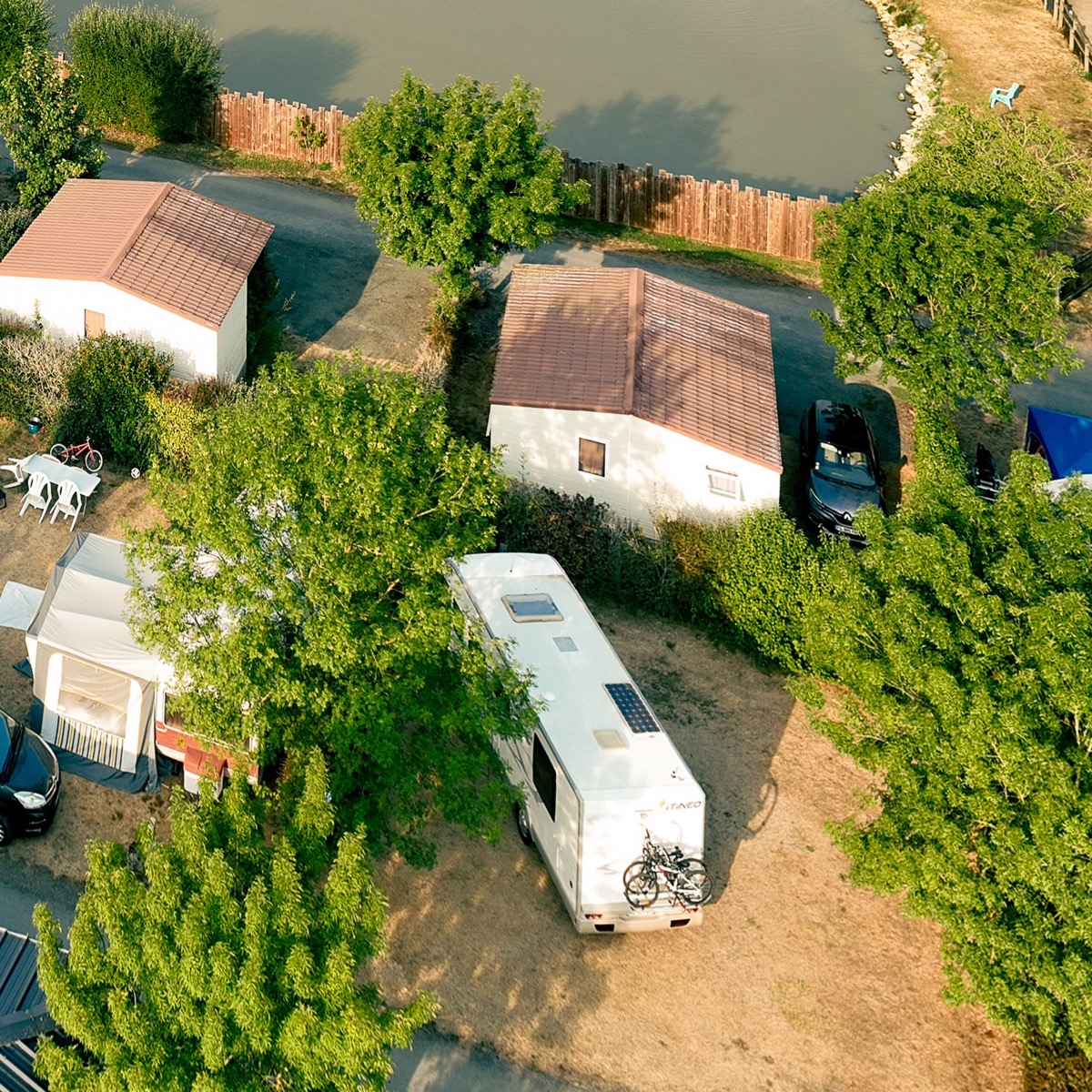 Camping-car avec porte-vélos installé sur un emplacement ombragé du camping, près du Puy du Fou